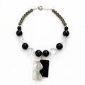 Collar de ónix, cristales facetados y dije de concha madre perla.